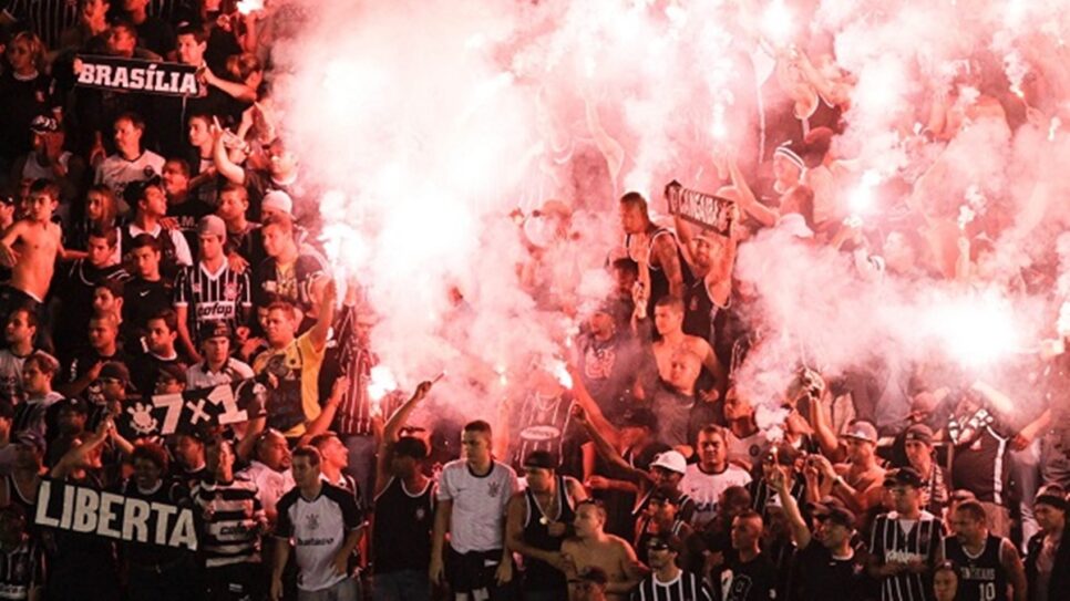 Torcida com sinalizadores na arquibancada de estádio