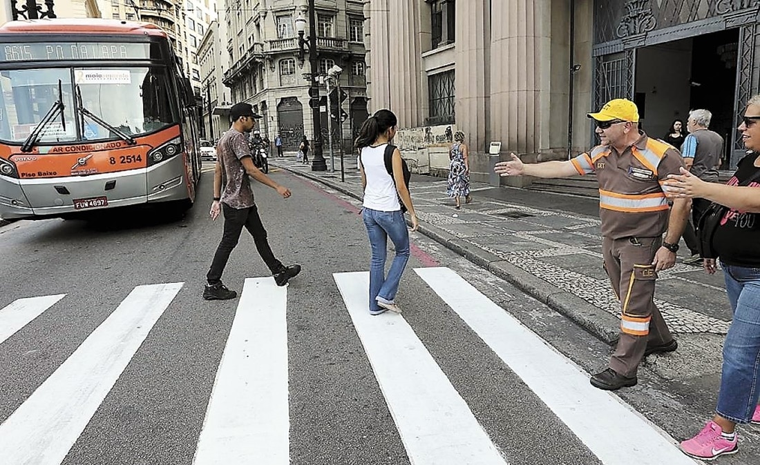 Guarda de trânsito orientando pedestres no centro de São Paulo 