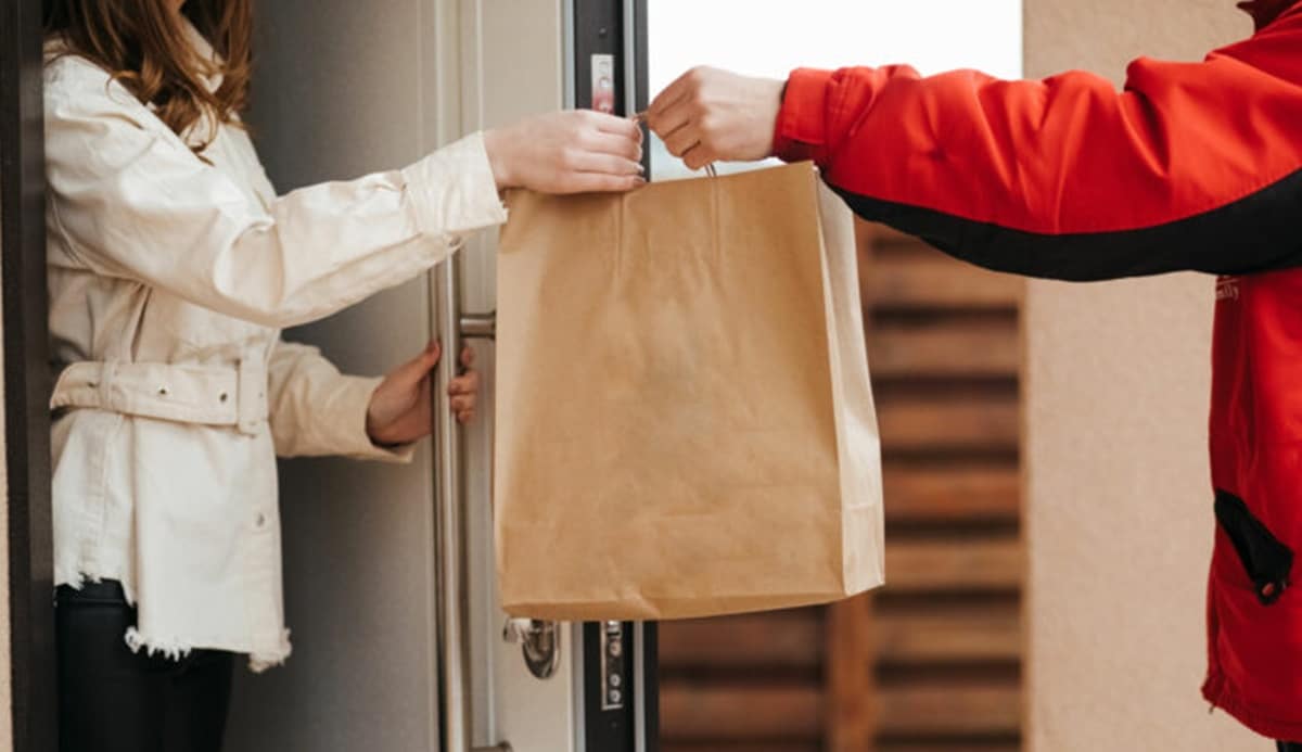 Entregador de aplicativo na porta de apartamento