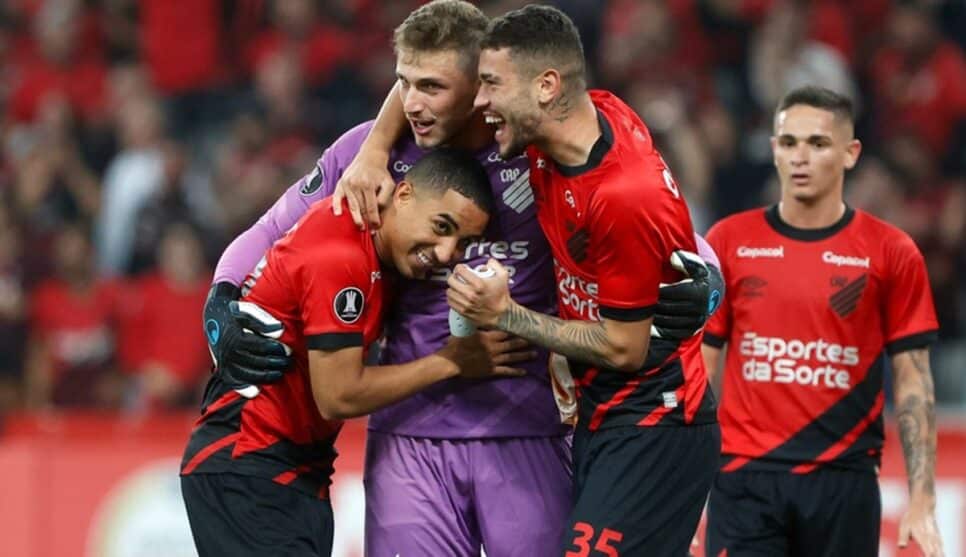 Bento sendo abraçado pela equipe de craques do Athletico na Libertadores