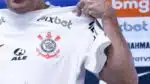 Estrela do Corinthians motrando a camisa do Timão em coletiva (Foto: Reprodução/ Ettore Chiereguini/ Agif/ Gazeta Press)