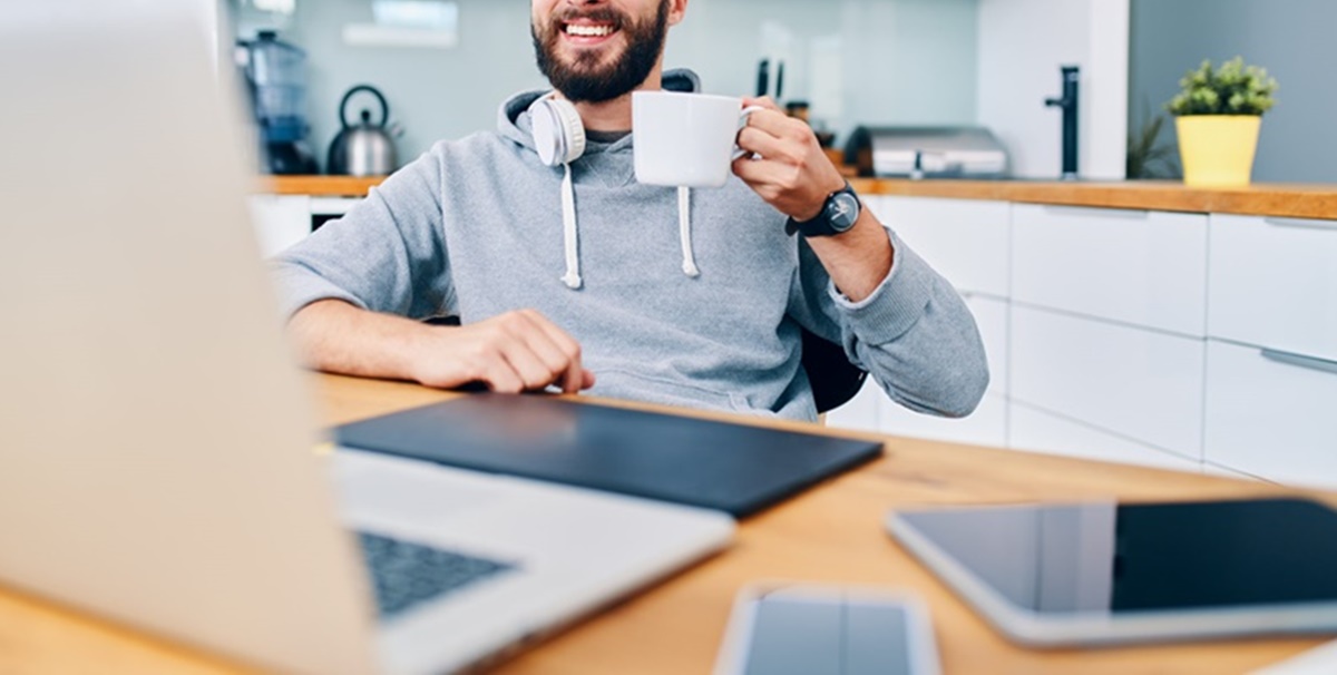 Homem trabalhando Home Office com Notebook e Celulares