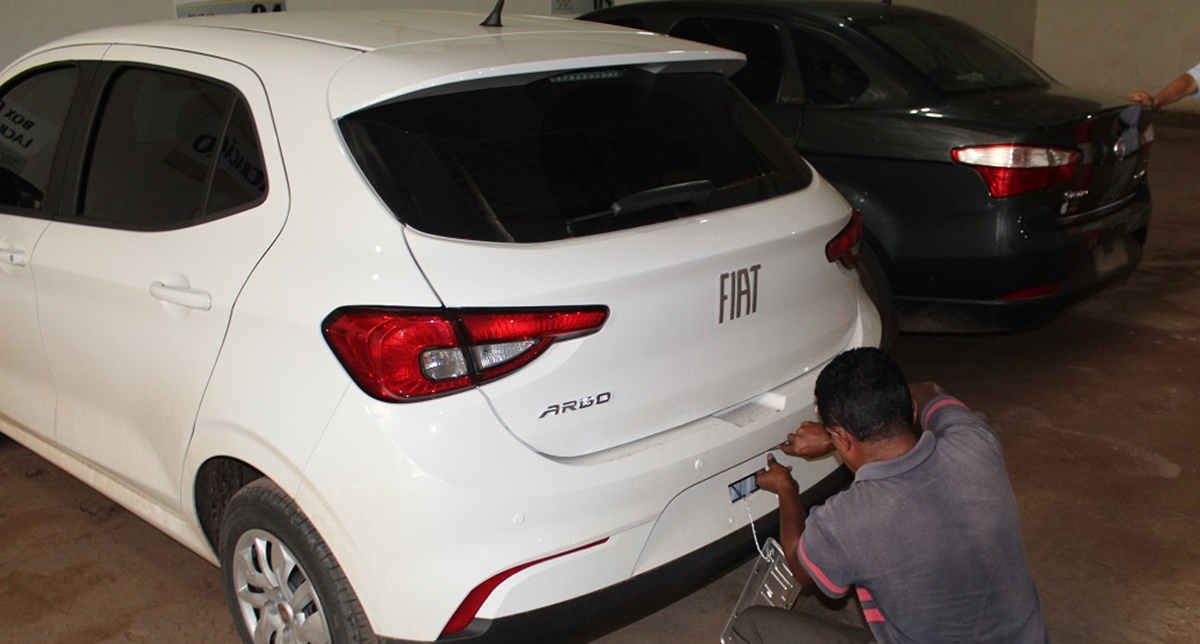 Homem instalando a placa de seu automóvel zero km