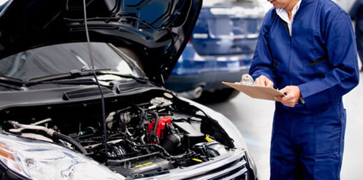 Profissional em mecânica analisando motor de carro com capô aberto (Foto: Reprodução/ Internet)