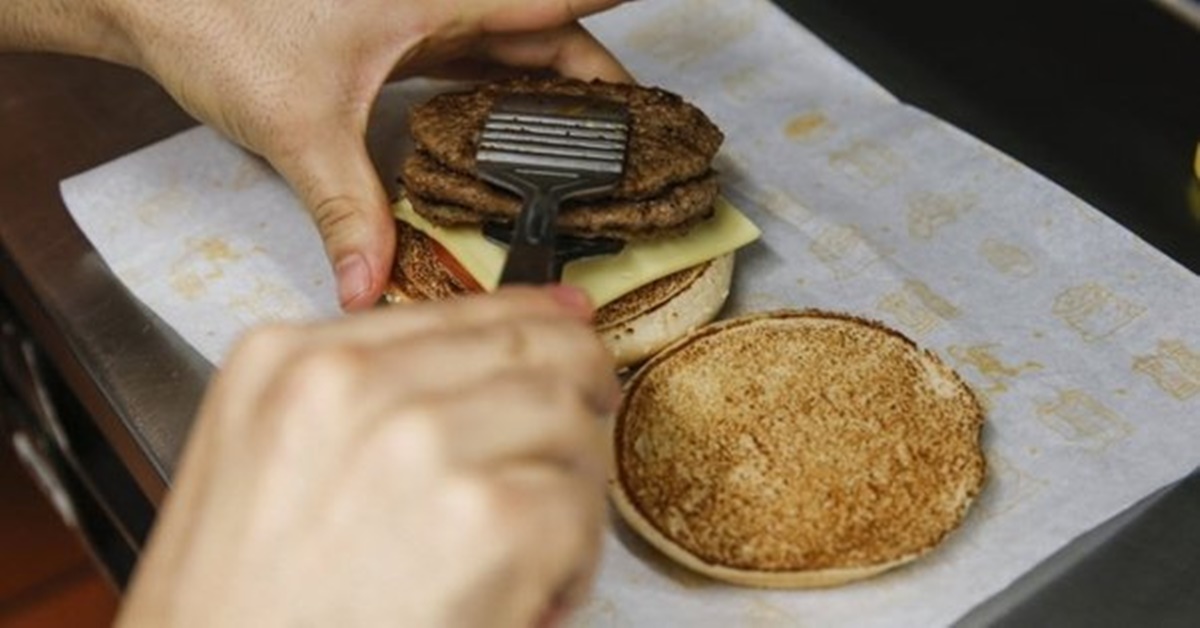 Funcionário do McDonalds colocando o hambúrguer no lanche; Justiça condena multa por insalubridade a menores de idade (Foto: Reprodução/ Internet)