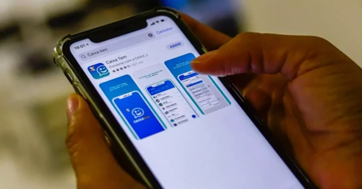Pessoa baixando o aplicativo do Caixa Tem em seu celular (Foto: Reprodução/ Marcelo Casal Jr/ Agência Brasil)