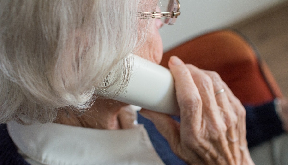 Senhora idosa atendendo o telefone; maneira que você fala ao atender número desconhecido pode ser armadilha (Foto: Reprodução/ GettyImages)