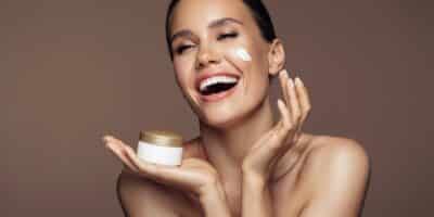 Mulher passando creme no rosto (Imagem: Reprodução/Internet)