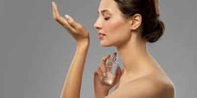 Mulher sentindo o cheiro de perfume (Imagem Reprodução Canva)
