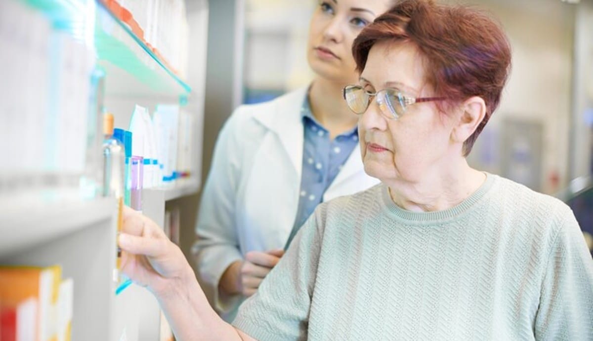 Mulher idosa comprando medicamento na farmácia após isenção do IPTU (Foto: Reprodução/ FreePik)